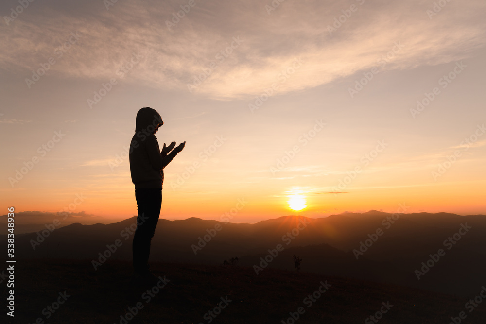 Silhouette of Christian woman praying worship at sunset. Christian Religion concept background. Hands  in prayer. worship god with religion concept.