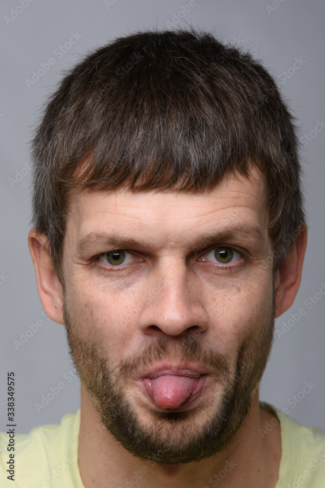 Portrait of a man of European appearance showing tongue, close-up Portrait of a man of European appearance showing tongue, close-up