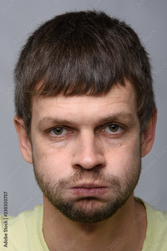 Closeup portrait of a resentful man of European appearance who pouted his cheeks Closeup portrait of a resentful man of European appearance who pouted his cheeks