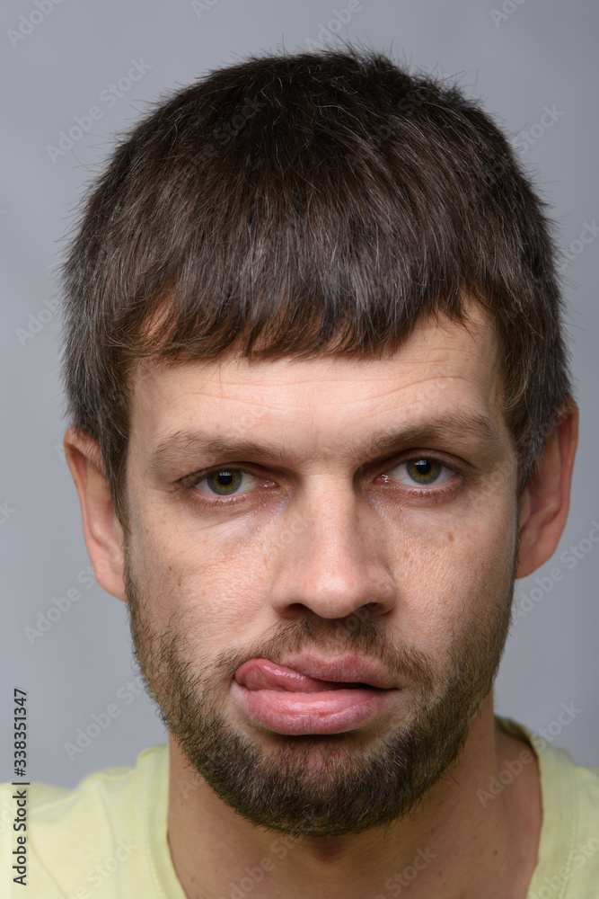 Portrait of a sad man of European appearance with his tongue hanging out, close-up Portrait of a sad man of European appearance with his tongue hanging out, close-up