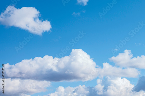 big white cumulus clouds in the blue sky as a natural background