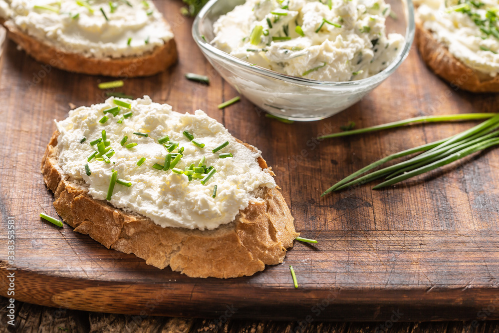 Ταπετσαρία Slices of crusty bread and a glass bowl with a cream cheese spread and cut chive