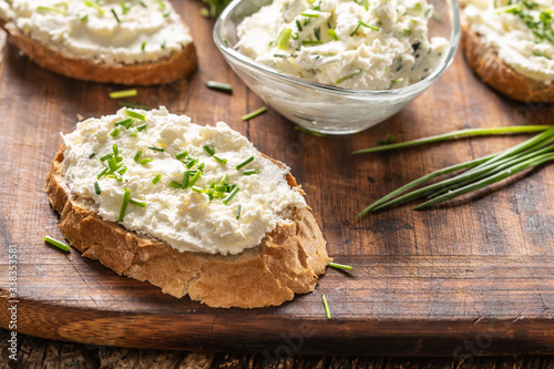 Φωτογραφία Slices of crusty bread and a glass bowl with a cream cheese spread and cut chive