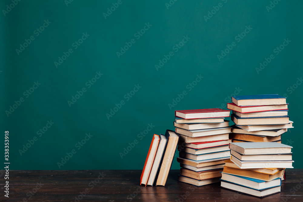many stacks of educational books to teach in the school library on a green background many stacks of educational books to teach in the school library on a green background