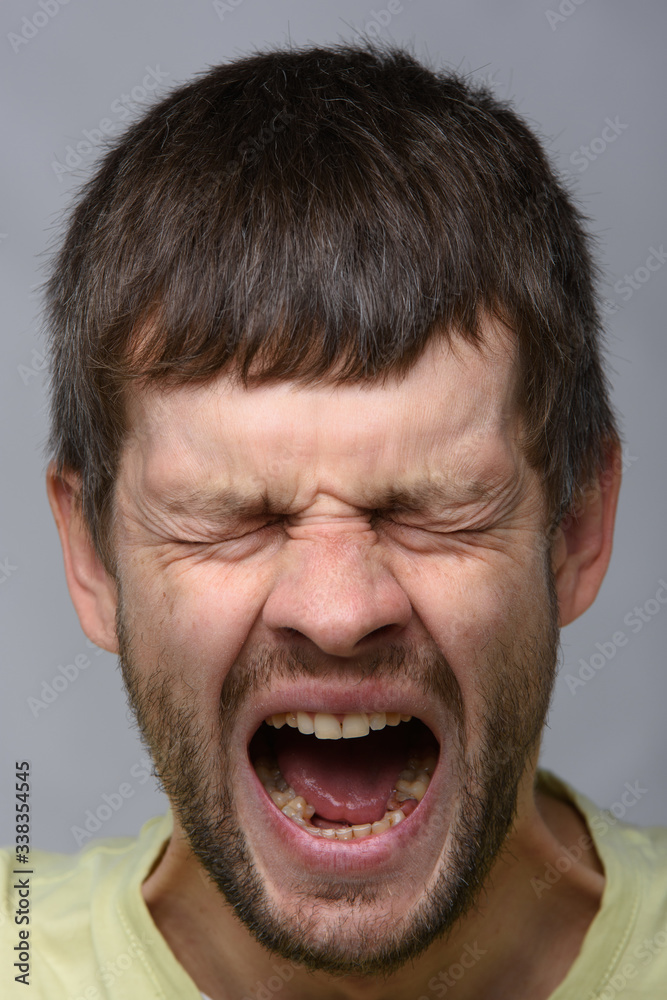Close-up portrait of a yawning man of European appearance with wide open mouth Close-up portrait of a yawning man of European appearance with wide open mouth