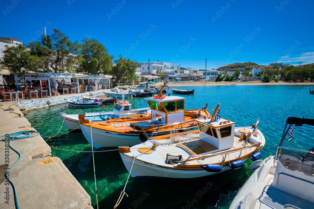 Fishing boats in harbour fishing village of Pollonia with fishing boats moored to pier in sea. Pollonia town, Milos island, Greece