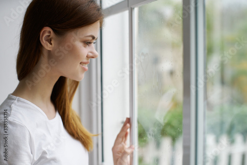 young woman looking out window