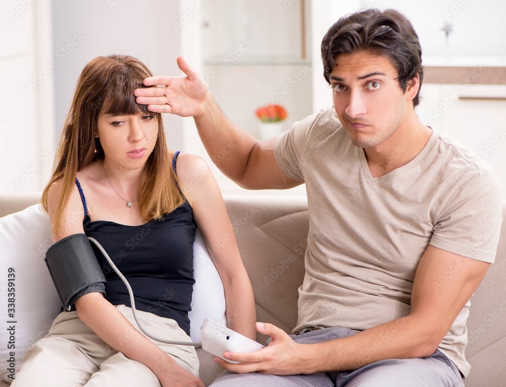 Fototapeta premium Husband checking wife's blood pressure