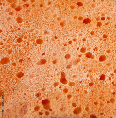 texture of wet orange washcloths with white foam, full frame
