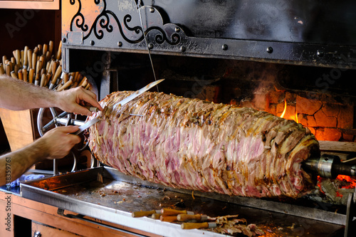 Cag Kebap, Traditional Turkish Kebap being prepared by chef. Slicing kebab to serve.