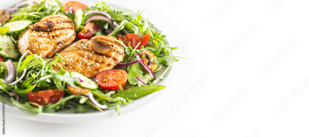 Healthy salad with grilled chicken topped with sesame seeds, rocket, spring peas, cherry tomatoes, sliced cucumber, grilled mushrooms and red onion, isolated on left half of the white background Healthy salad with grilled chicken topped with sesame seeds, rocket, spring peas, cherry tomatoes, sliced cucumber, grilled mushrooms and red onion, isolated on left half of the white background