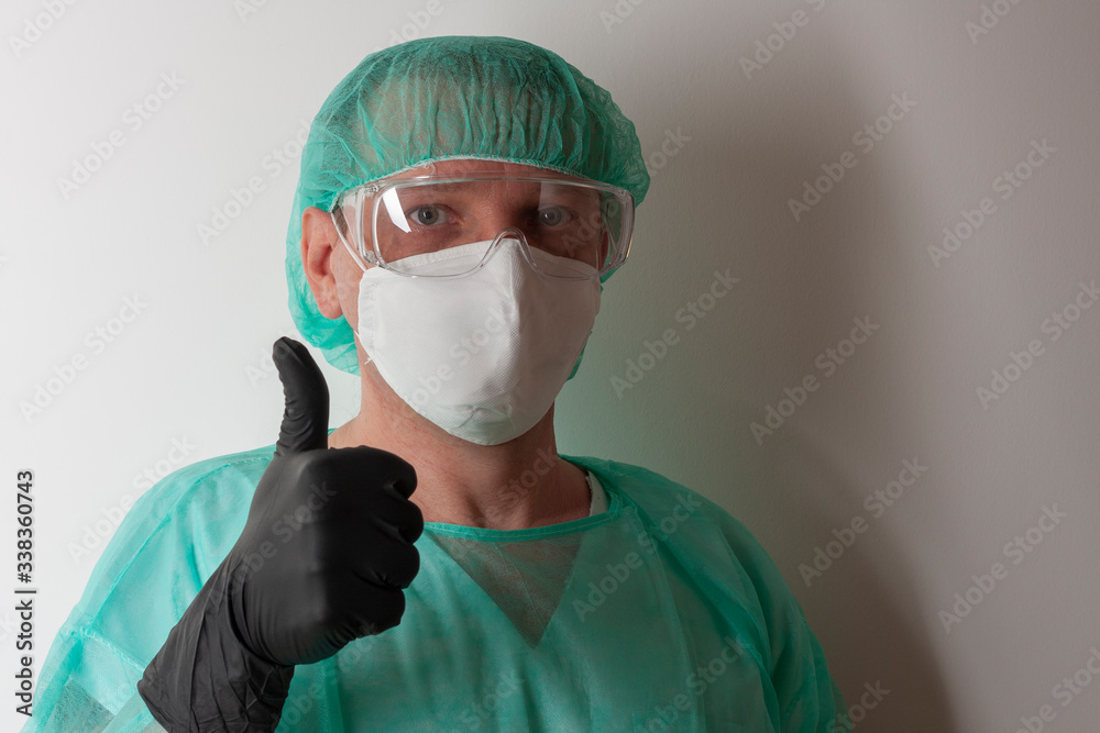 Male nurse, with plastic protective eyeglasses and respirator ffp2, cap, gown, gloves, with personal protective equipment to protect against the virus covid-19 in ICU in hospital. Male nurse, with plastic protective eyeglasses and respirator ffp2, cap, gown, gloves, with personal protective equipment to protect against the virus covid-19 in ICU in hospital.