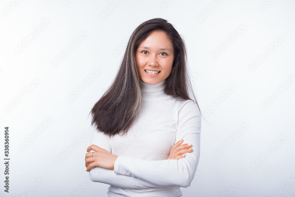 Simple portrait of a smiling asian girl with arms crossed on white background. Simple portrait of a smiling asian girl with arms crossed on white background.