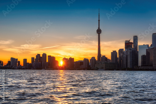 Skyline of Toronto at sunset with CN Tower over Ontario Lake, Canada.