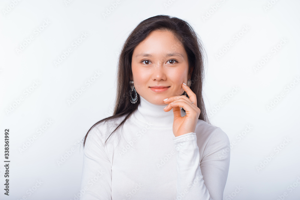 Gentle young woman portrait on white background while she is touching her face. Gentle young woman portrait on white background while she is touching her face.