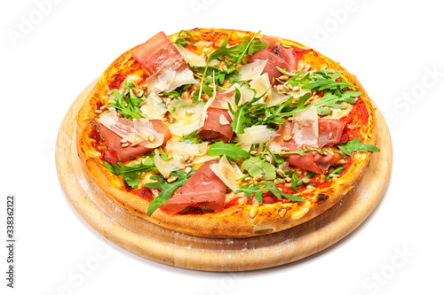 Pizza with dry cured ham, parmesan cheese, rocket and pine nuts on wooden platter, isolated with clipping path