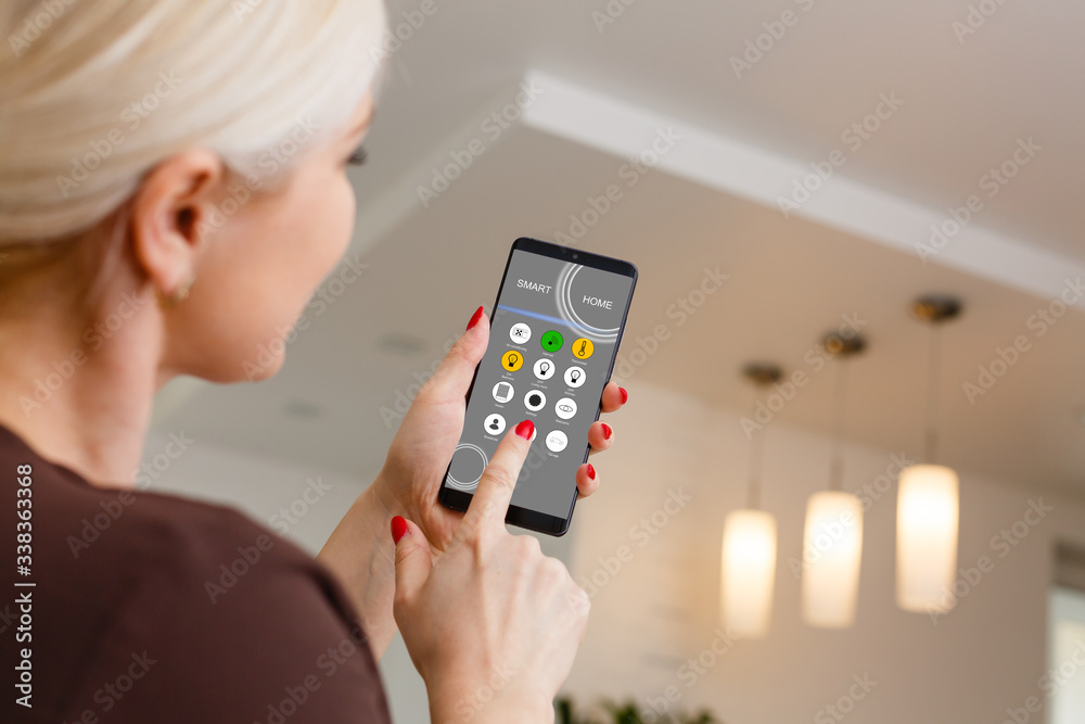 Smart Home: Woman Controlling Lights With App On His Phone Smart Home: Woman Controlling Lights With App On His Phone