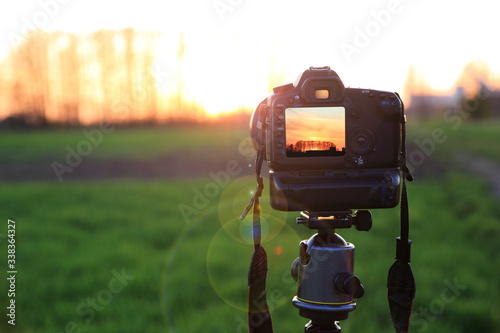 Aparat fotograficzny z krajobrazem zachodzącego słońca na obszarze wiejskim.