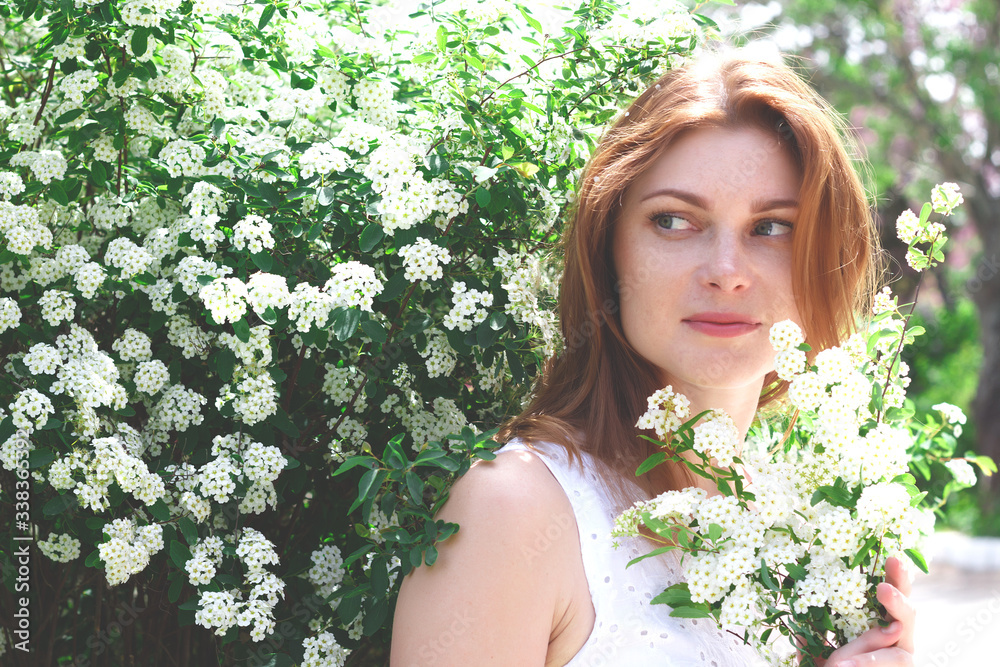 beautiful red-haired woman with freckles surrounded by white flowers beautiful red-haired woman with freckles surrounded by white flowers