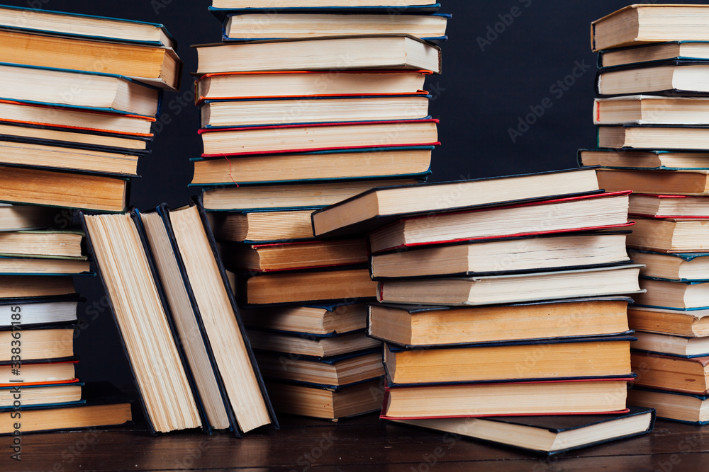 many stacks of educational books to teach in the library on a black background