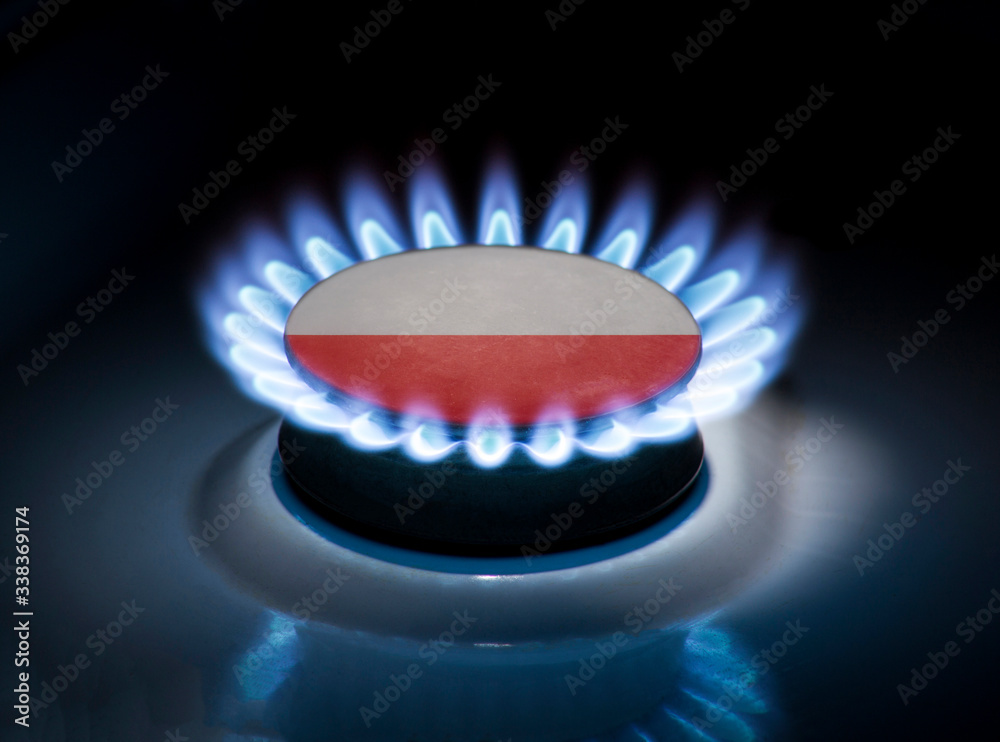 Burning gas burner of a home stove in the middle of which is the flag of the country of Poland. Gas import and export delivery concept, price per cubic meter, transit, background Burning gas burner of a home stove in the middle of which is the flag of the country of Poland. Gas import and export delivery concept, price per cubic meter, transit, background