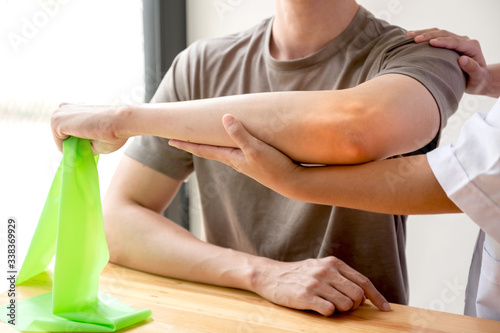 Female physiotherapists provide assistance to male patients with elbow injuries examine patients in rehabilitation centers. Physiotherapy concepts