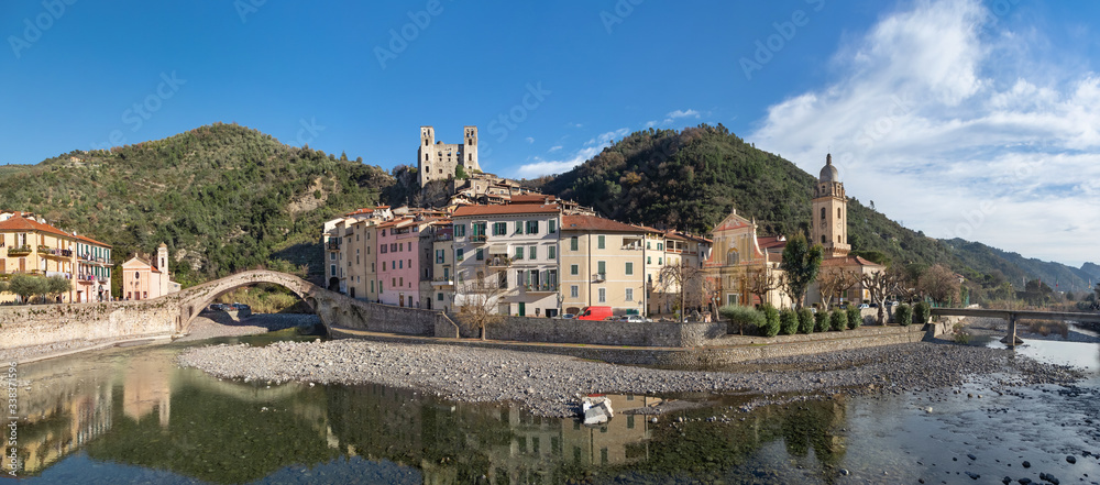 Dolceacqua, Italy. Panorama of the town with romanesque bridge (Ponte Vecchio), over the Nervia river and ruins of medieval castle