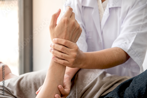 Female physiotherapists provide assistance to male patients with elbow injuries examine patients in rehabilitation centers. Physiotherapy concepts
