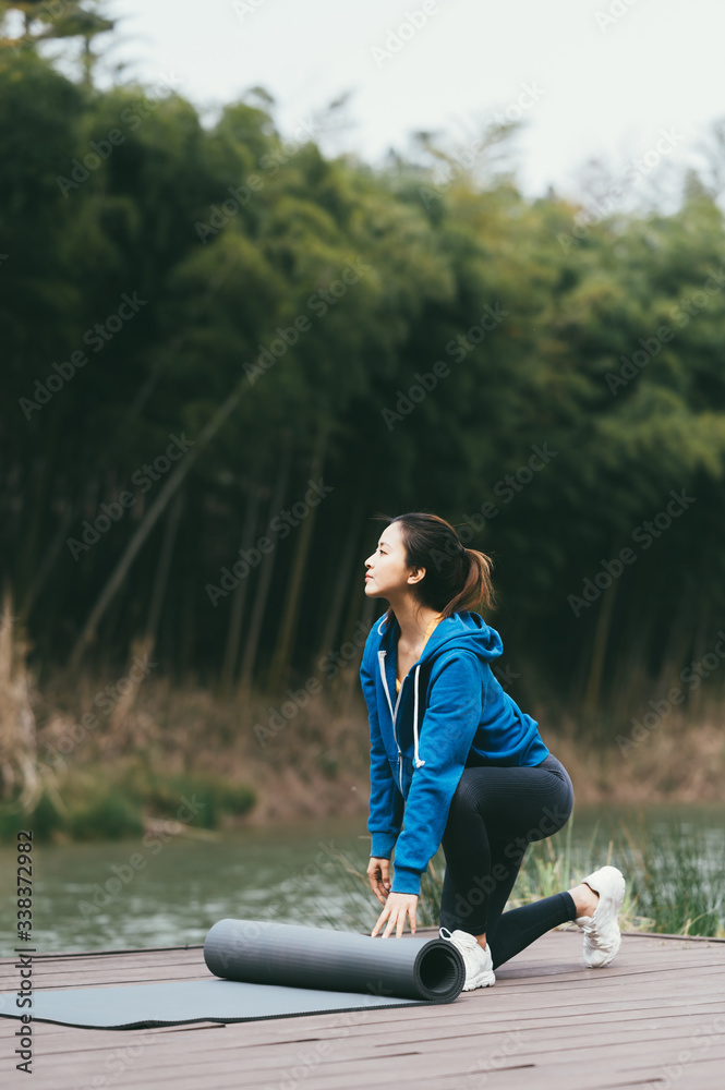 young asian beauty woman doing yoga beside the lake