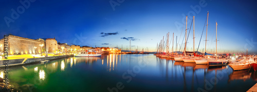 Night view of the Alghero Marina yacht port at the Gulf of Alghero with anchored sailboats © pilat666
