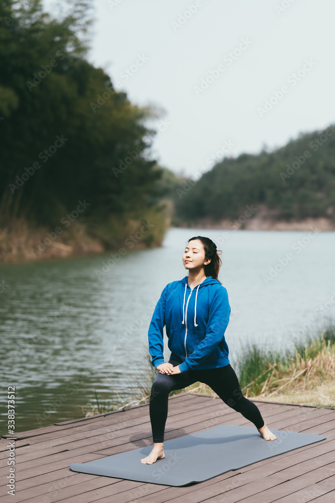 young asian beauty woman doing yoga beside the lake