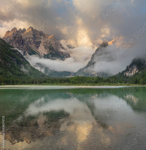 Mountains Lake at the foggy morning, wild forest dnd Alps Mountains