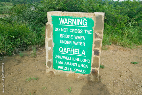 Obvious sign warns not to cross bridge when under water in Umfolozi Game Reserve, South Africa, established in 1897 photo