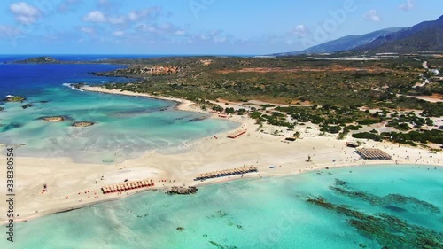 Forward moving aerial showing magnificent view of Elafonisi lagoon, Crete, Greece with pink sands and sandbar with shallow waters.