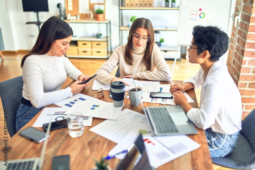 Beautiful businesswomen smiling happy. Sitting with smile on face working using smartphone and laptop at the office Beautiful businesswomen smiling happy. Sitting with smile on face working using smartphone and laptop at the office
