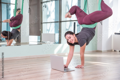 Photo of young woman practicing yoga indoor. Beautiful girl practice yoga in class. Yoga studio instructor. Blurred background.