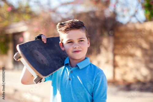 Foto Kid boy with skateboard. Childhood, leasure and lifestyle concept