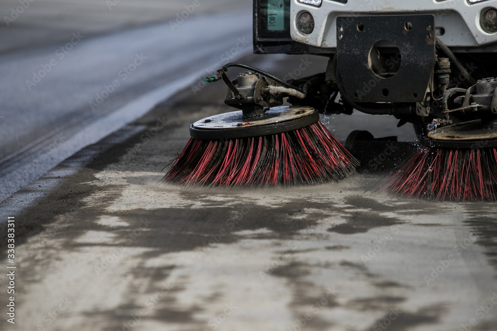 Φωτογραφία Street cleaner vehicle on the road collecting garbage and junk with brush rotati