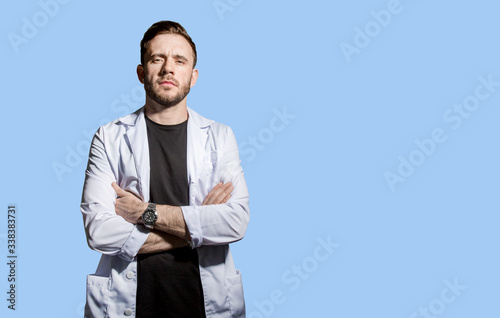 Confident doctor in a white coat crossed his arms over his chest, confronting the covid-19 virus. horizontal orientation concept on a white background. Sample text. Concept - covid-19 pandemic  photo