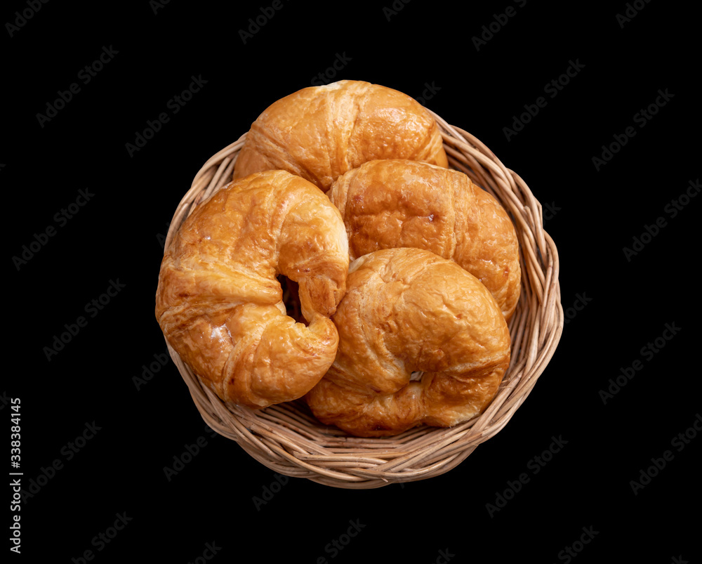 Croissant in the Wicker basket on the black background Croissant in the Wicker basket on the black background