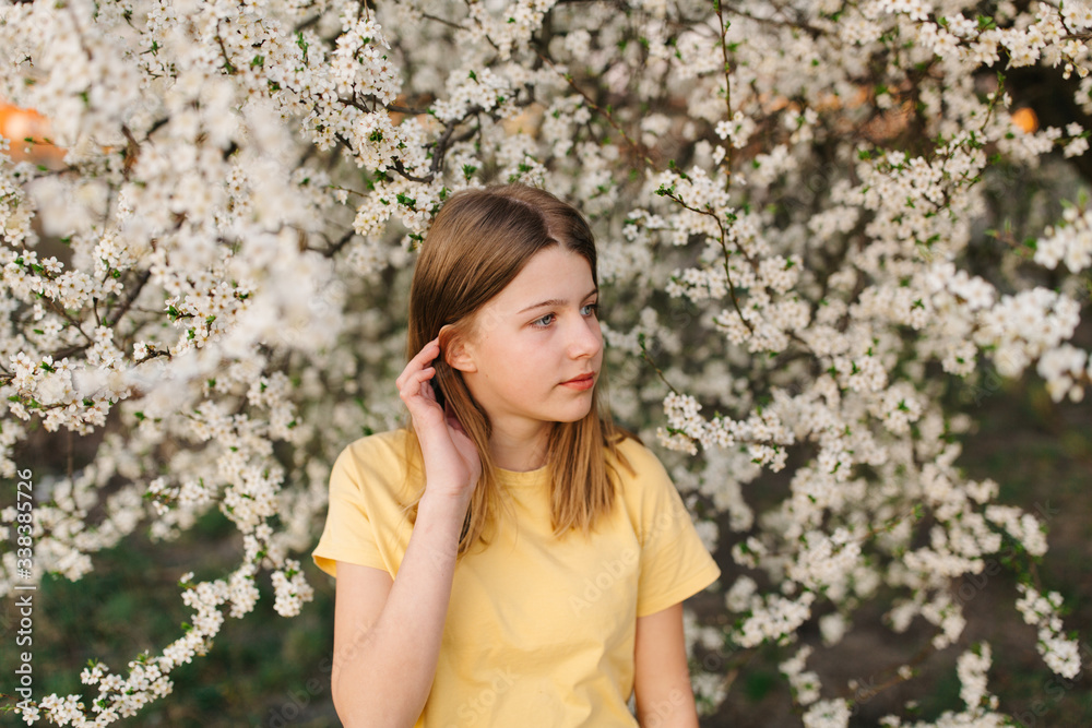 Portrait of young beautiful blonde woman near blooming tree with white flowers on a sunny day. Spring, girl near a flowering tree.beautiful girl in a yellow t-shirt near a flowering tree Portrait of young beautiful blonde woman near blooming tree with white flowers on a sunny day. Spring, girl near a flowering tree.beautiful girl in a yellow t-shirt near a flowering tree