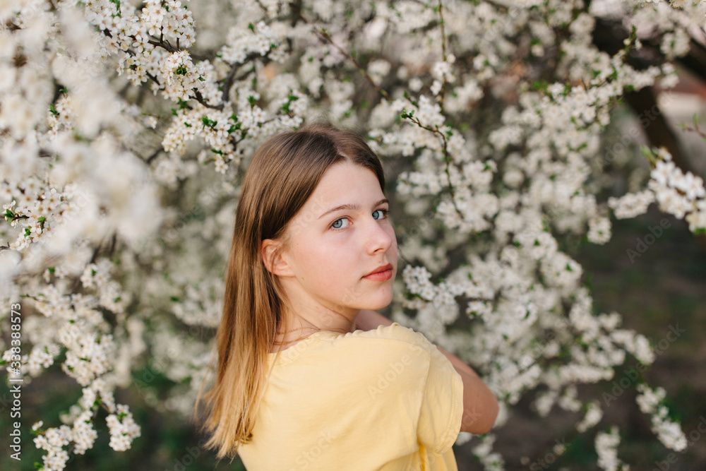 portrait of sad young woman in protective medical face mask with flowers near blooming tree in spring time. Coronavirus protection. epidemic of coronavirus. the aroma a tree in the garden on a spring portrait of sad young woman in protective medical face mask with flowers near blooming tree in spring time. Coronavirus protection. epidemic of coronavirus. the aroma a tree in the garden on a spring