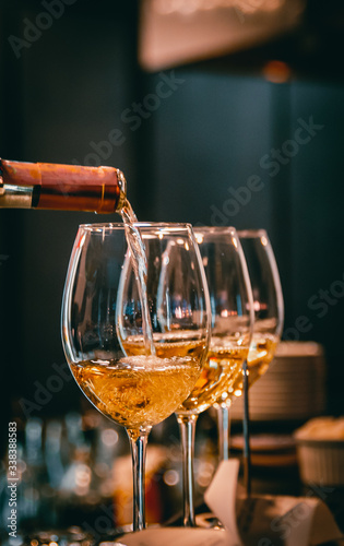 bartender pouring white wine into a glass in cafe or bar
