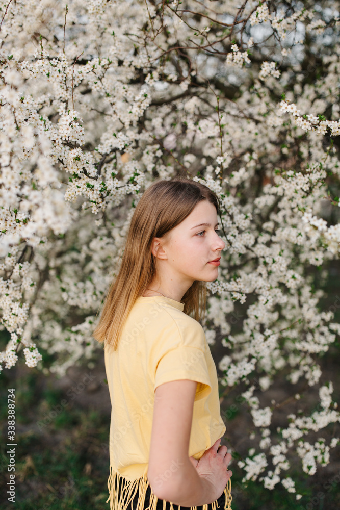 portrait of sad young woman in protective medical face mask with flowers near blooming tree in spring time. Coronavirus protection. epidemic of coronavirus. the aroma a tree in the garden on a spring portrait of sad young woman in protective medical face mask with flowers near blooming tree in spring time. Coronavirus protection. epidemic of coronavirus. the aroma a tree in the garden on a spring