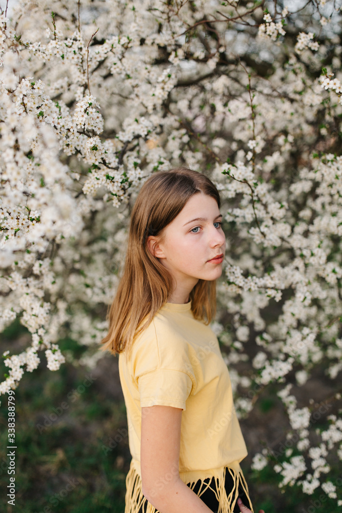 portrait of sad young woman in protective medical face mask with flowers near blooming tree in spring time. Coronavirus protection. epidemic of coronavirus. the aroma a tree in the garden on a spring portrait of sad young woman in protective medical face mask with flowers near blooming tree in spring time. Coronavirus protection. epidemic of coronavirus. the aroma a tree in the garden on a spring