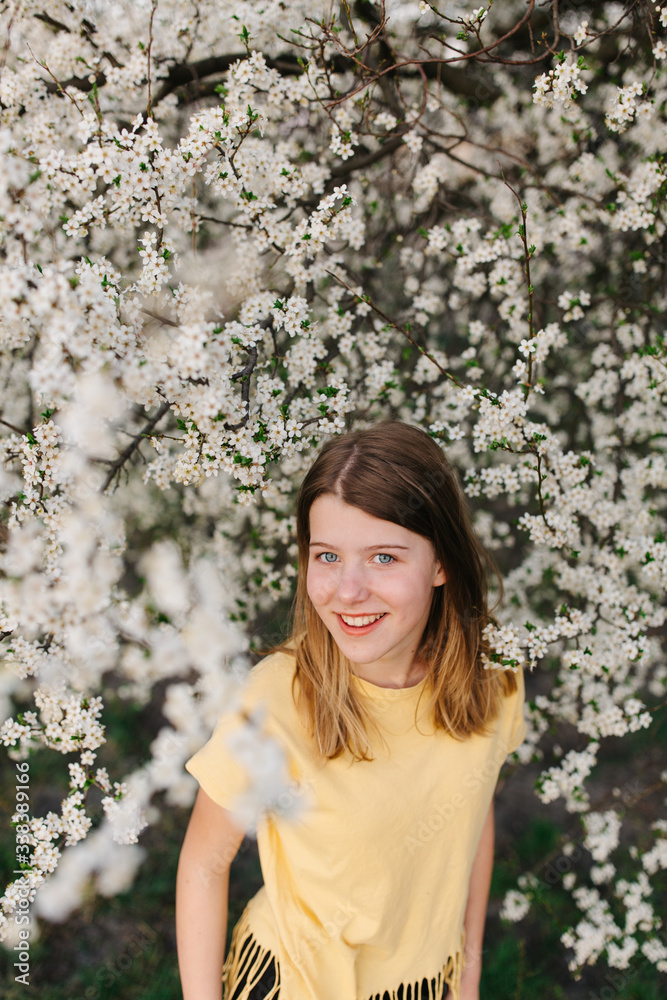 portrait of sad young woman in protective medical face mask with flowers near blooming tree in spring time. Coronavirus protection. epidemic of coronavirus. the aroma a tree in the garden on a spring portrait of sad young woman in protective medical face mask with flowers near blooming tree in spring time. Coronavirus protection. epidemic of coronavirus. the aroma a tree in the garden on a spring