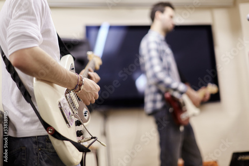 Musicians play electric guitars during a practice session