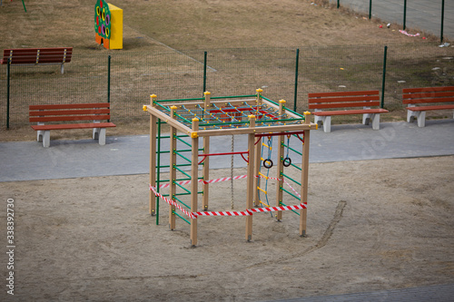 Playground is closed for quarantine, the playground is blocked by a red warning tape, children cannot play on the street