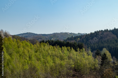 View over hilly landscape with trees and forests in spring