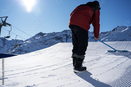 Billede på lærred Shaper with a shapetool shaping a kicker in a snowpark in St